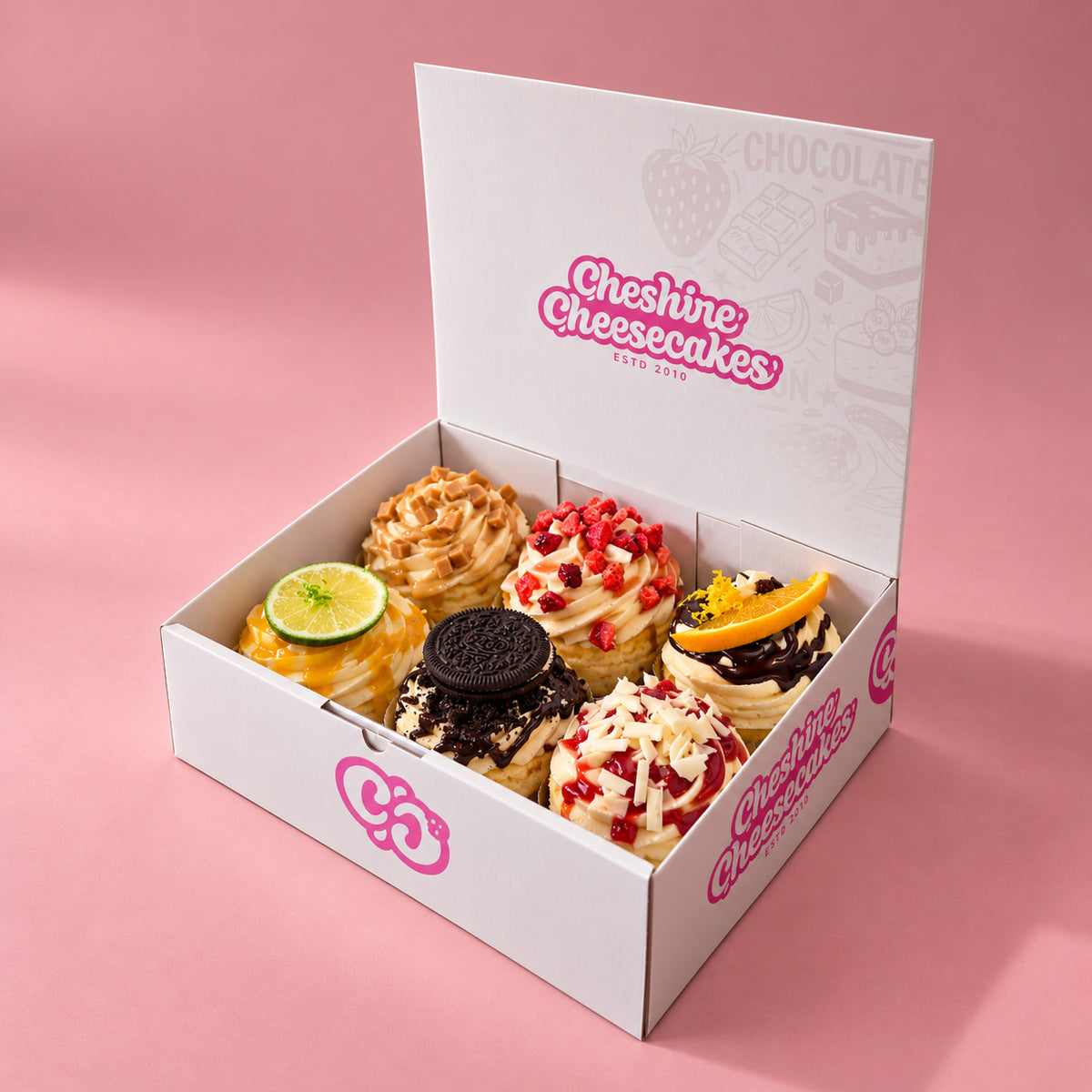 Build Your Own Cheesecake Box: example customer-chosen selection of 6 cheesecakes in our branded open box on blush pink
